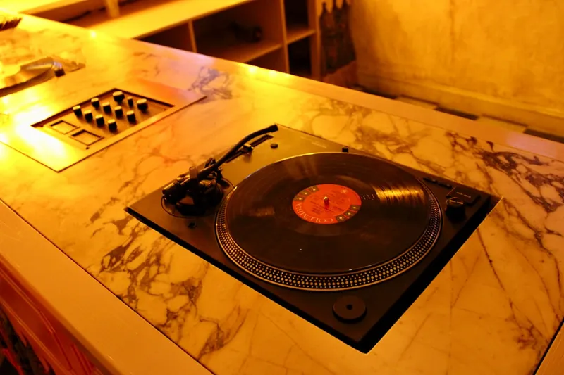 Turntable with vinyl record on marble counter